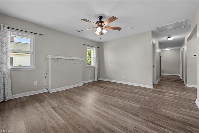 empty room with baseboards, ceiling fan, wood finished floors, and visible vents