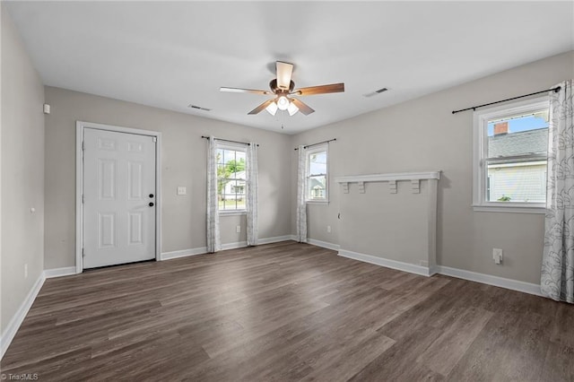 interior space featuring baseboards, ceiling fan, wood finished floors, and visible vents