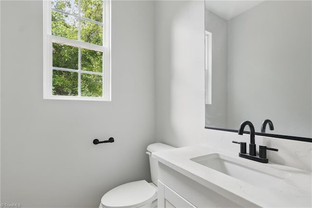 half bathroom with toilet and vanity