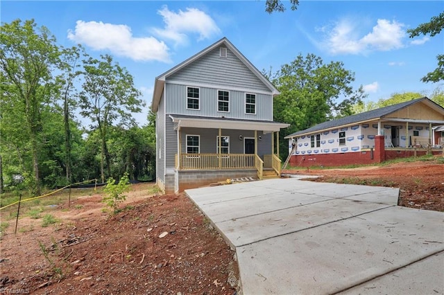view of front of property featuring a porch and concrete driveway