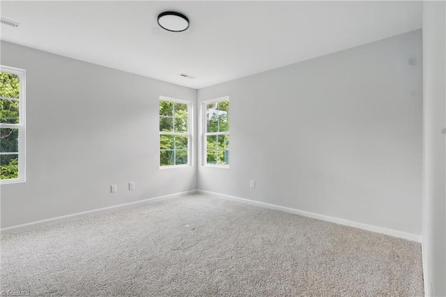 carpeted empty room featuring baseboards