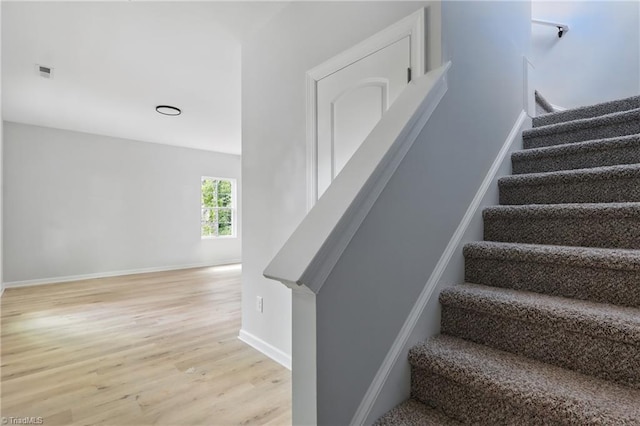 staircase with wood finished floors and baseboards