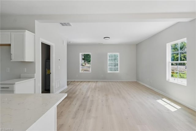 unfurnished living room featuring light wood-type flooring and baseboards