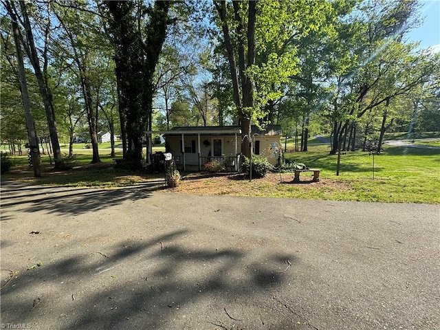 bungalow-style home featuring a front yard, aphalt driveway, and covered porch