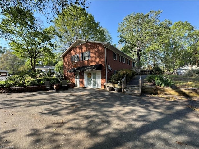 exterior space featuring brick siding and driveway
