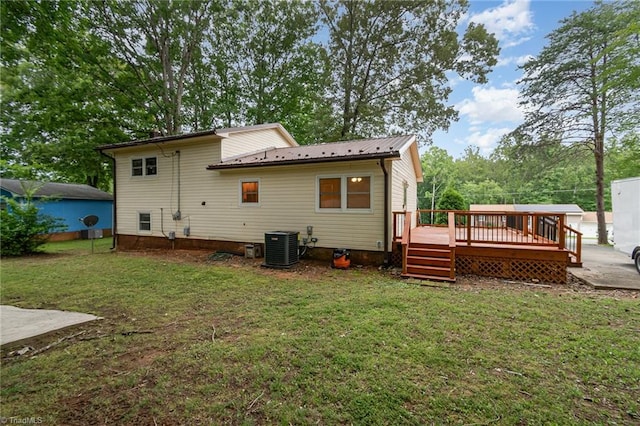 rear view of house with a lawn, cooling unit, and a deck