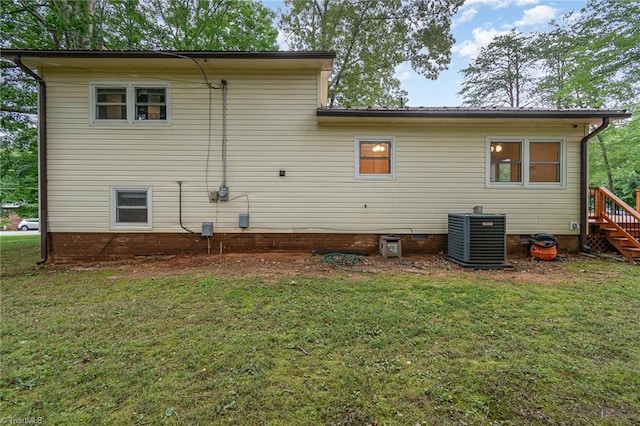 back of property with a lawn and central AC unit