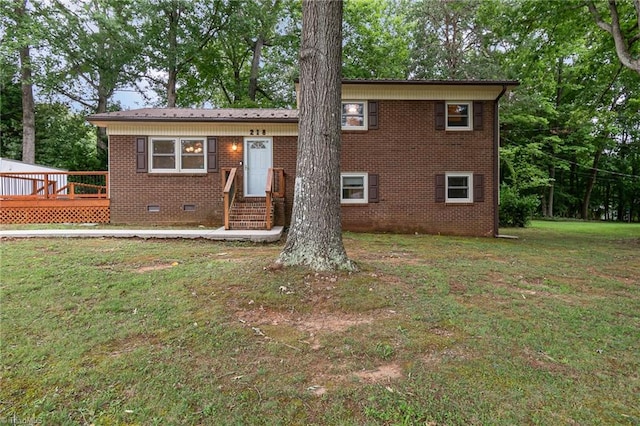 rear view of house featuring a wooden deck and a yard