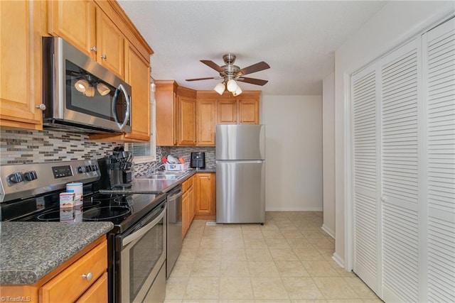 kitchen featuring ceiling fan, tasteful backsplash, appliances with stainless steel finishes, and light tile patterned floors