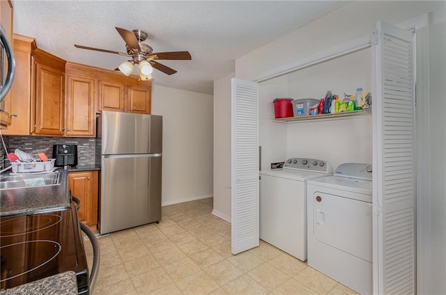 interior space featuring washer and dryer, ceiling fan, stainless steel refrigerator, light tile patterned flooring, and stove