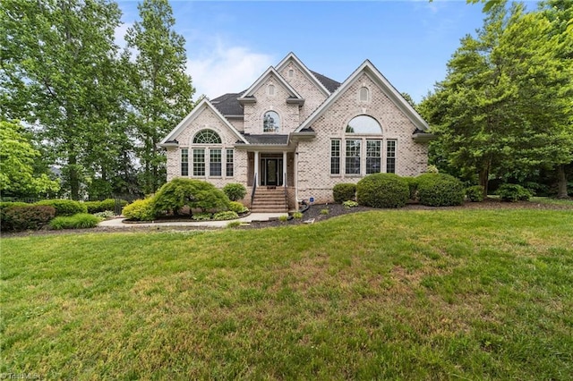 view of front of property featuring brick siding and a front lawn
