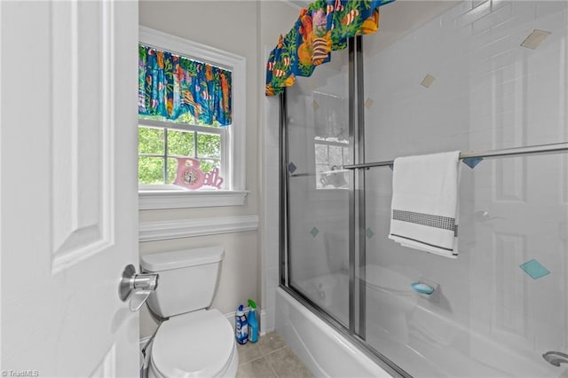 full bath featuring tile patterned floors, shower / bath combination with glass door, and toilet