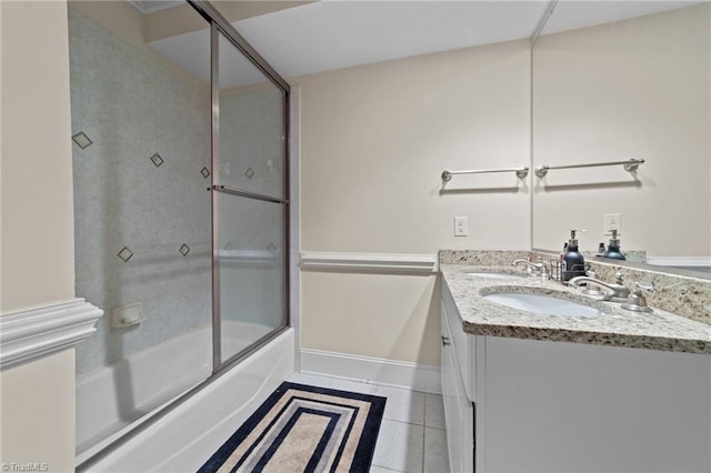 bathroom featuring double vanity, enclosed tub / shower combo, tile patterned flooring, and baseboards
