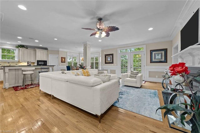 living room with ornamental molding, plenty of natural light, light wood-style flooring, french doors, and recessed lighting