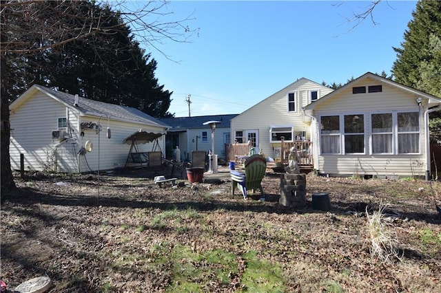 rear view of property with a sunroom and a deck