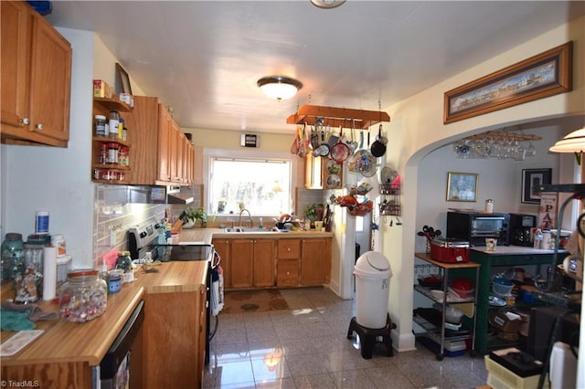 kitchen featuring electric stove, wood counters, sink, and backsplash