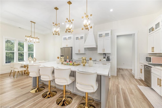138 Arthur Needham Rd, Pilot Mountain, NC 27041 - kitchen featuring stainless steel appliances, custom range hood, a chandelier, backsplash, and light wood-type flooring