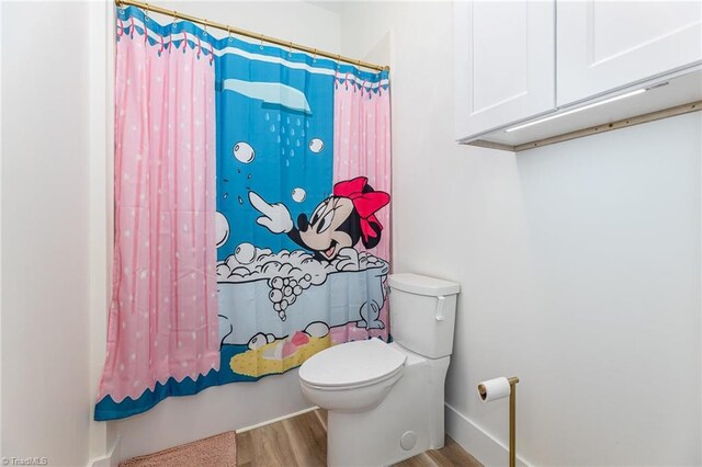 138 Arthur Needham Rd, Pilot Mountain, NC 27041 - full bathroom featuring toilet, wood finished floors, and shower / bath combo with shower curtain