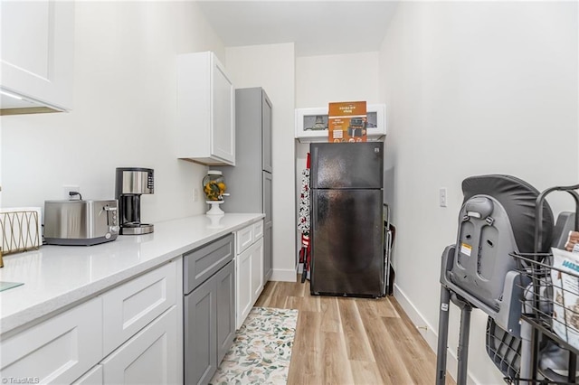 138 Arthur Needham Rd, Pilot Mountain, NC 27041 - kitchen with freestanding refrigerator, light wood-style floors, light countertops, white cabinets, and baseboards