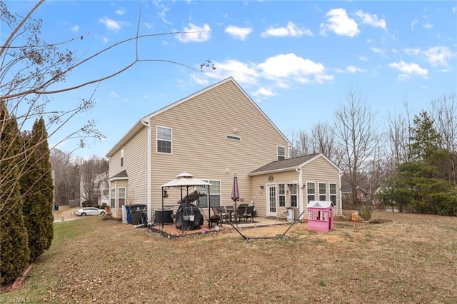 rear view of house featuring a gazebo, a patio area, a lawn, and central air condition unit