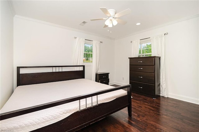 bedroom featuring crown molding, baseboards, multiple windows, and wood finished floors