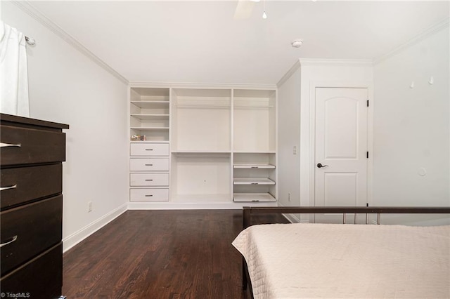 bedroom with a closet, dark wood finished floors, baseboards, and ornamental molding