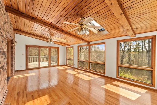 unfurnished sunroom featuring ceiling fan, vaulted ceiling with skylight, and wood ceiling