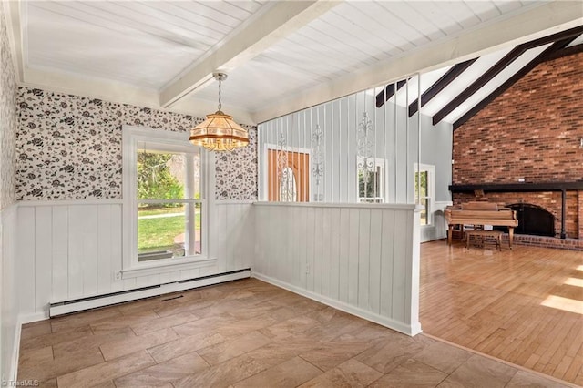 unfurnished dining area featuring a chandelier, lofted ceiling with beams, a baseboard radiator, and a fireplace