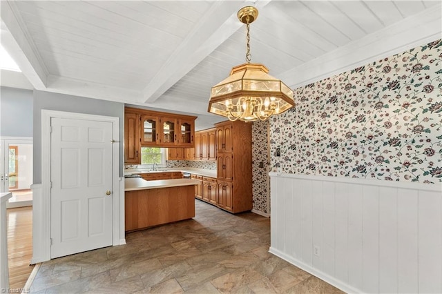 kitchen with kitchen peninsula, backsplash, sink, decorative light fixtures, and an inviting chandelier