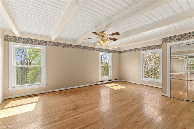 empty room with beam ceiling, ceiling fan, light hardwood / wood-style flooring, and a healthy amount of sunlight