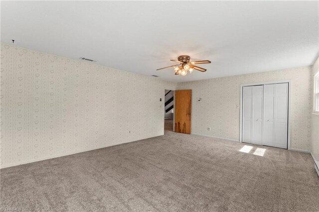 unfurnished bedroom with ceiling fan and carpet