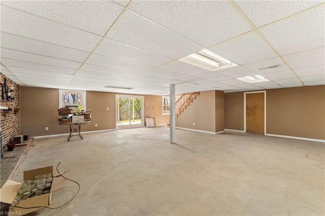 basement with carpet flooring, a drop ceiling, and a brick fireplace