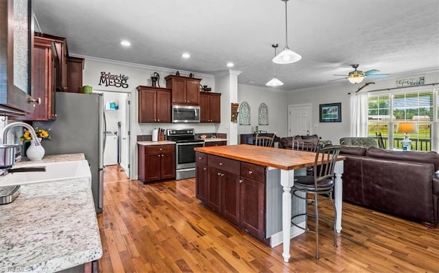 6770 Cotton Rd, Gibsonville, NC 27249 - kitchen featuring stainless steel appliances, open floor plan, crown molding, a breakfast bar area, and butcher block countertops