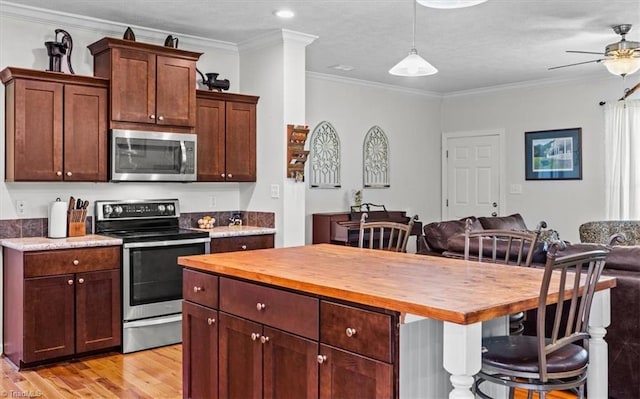 6770 Cotton Rd, Gibsonville, NC 27249 - kitchen featuring stainless steel appliances, butcher block counters, ornamental molding, light wood finished floors, and open floor plan