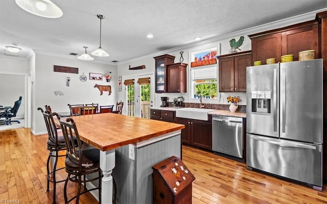 6770 Cotton Rd, Gibsonville, NC 27249 - kitchen with appliances with stainless steel finishes, ornamental molding, french doors, light wood-type flooring, and butcher block countertops