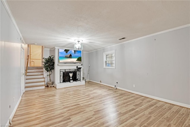 unfurnished living room with wood-type flooring, ornamental molding, and a textured ceiling