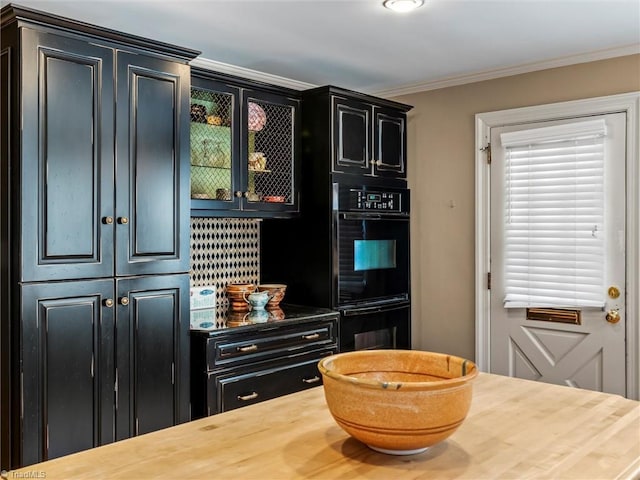 kitchen featuring glass insert cabinets, crown molding, dobule oven black, and dark cabinets