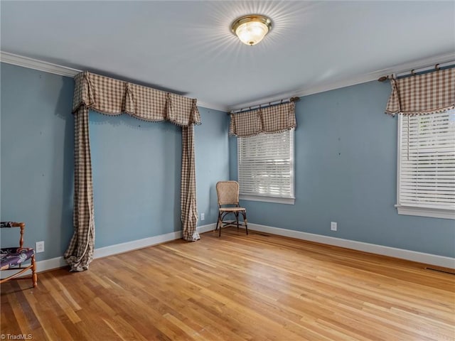 unfurnished room featuring crown molding, wood finished floors, and baseboards