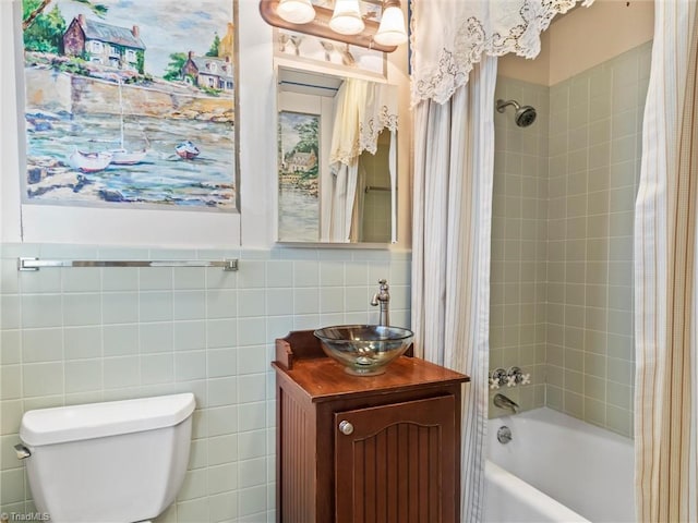 full bath featuring shower / tub combo with curtain, tile walls, vanity, and toilet