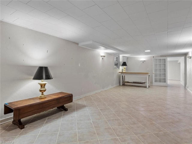 finished basement with light tile patterned floors and baseboards