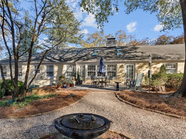 rear view of property featuring a patio and a chimney