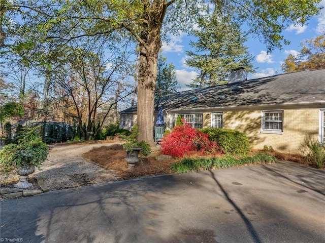 view of front of house with brick siding and a chimney