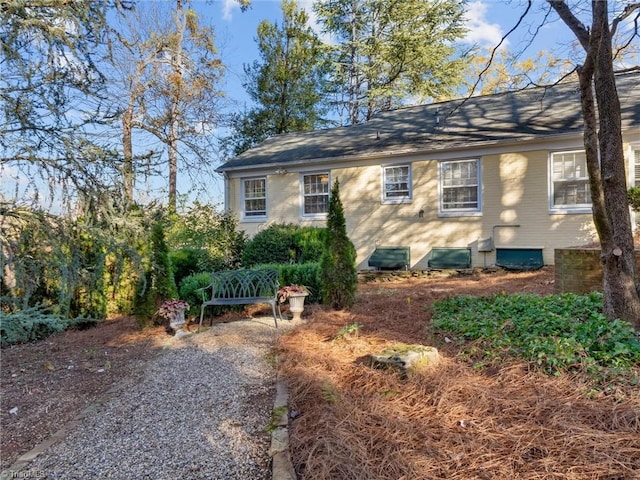 back of house featuring a shingled roof