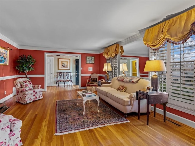 living room featuring crown molding, wood finished floors, and baseboards