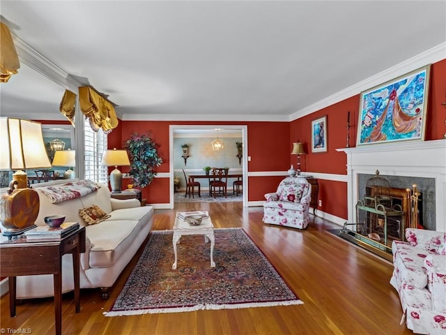 living room featuring a fireplace, wood finished floors, and crown molding