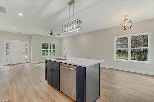 kitchen featuring dishwasher, ceiling fan with notable chandelier, pendant lighting, and a center island with sink