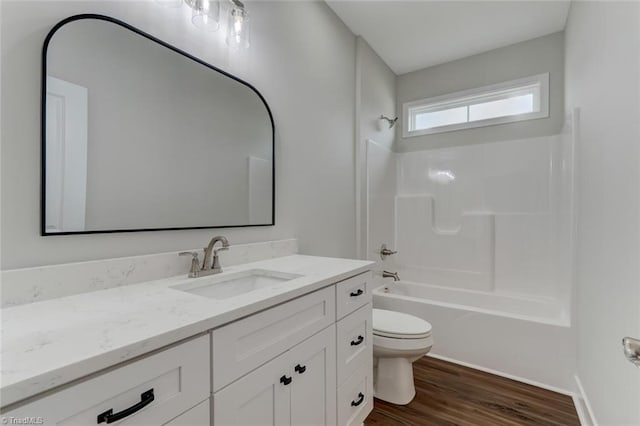 full bathroom with bathtub / shower combination, hardwood / wood-style floors, vanity, and toilet