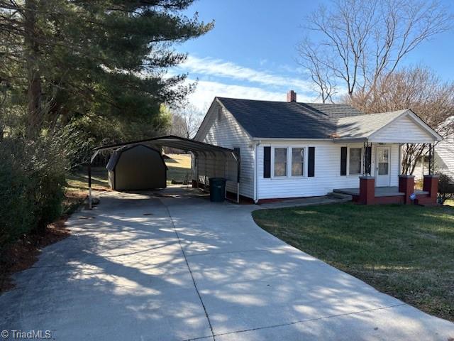 view of front of home featuring a carport, a porch, and a front yard