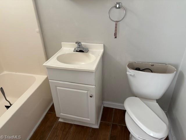 bathroom featuring vanity, hardwood / wood-style flooring, toilet, and a bathing tub