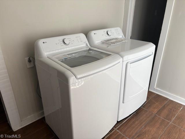 laundry room featuring washing machine and clothes dryer and dark hardwood / wood-style flooring